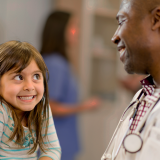 Young girl smiling at her doctor